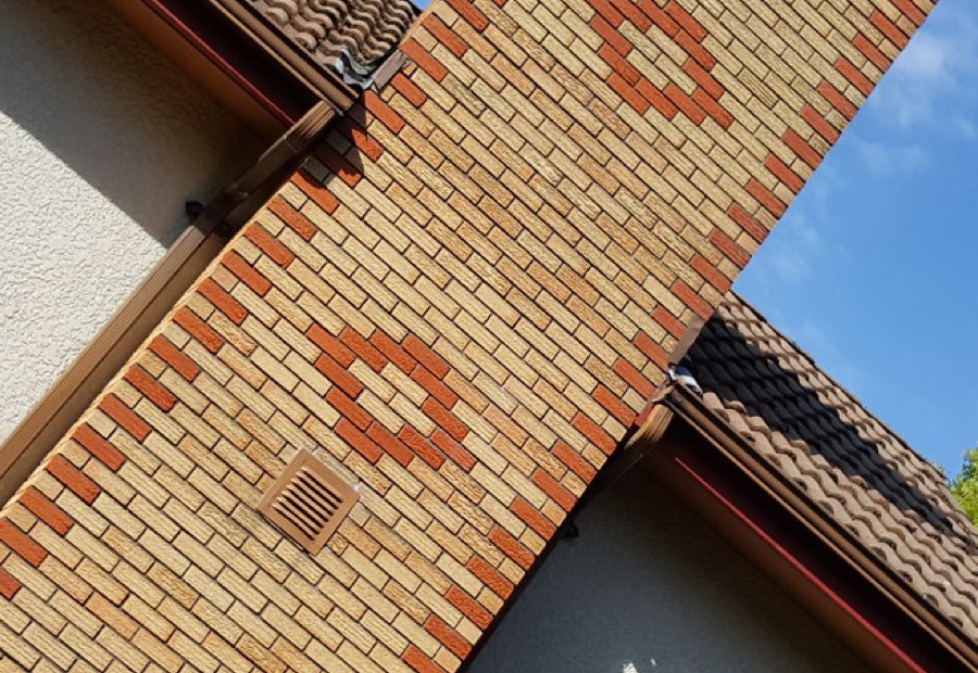 Brick chimney above an Erie roofline with a cracked crown and spalling brick