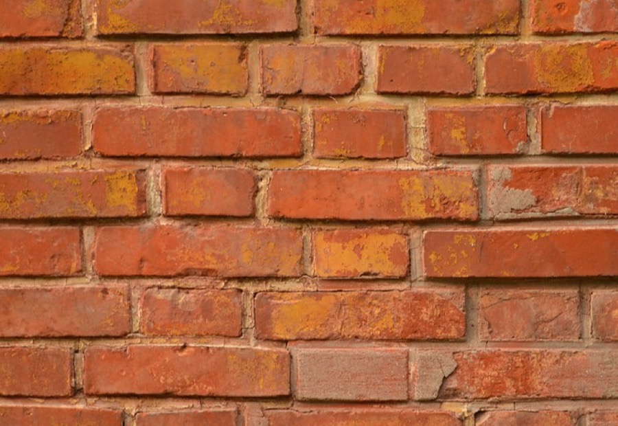 Breathable sealer being applied to an Erie brick wall with a low-pressure sprayer