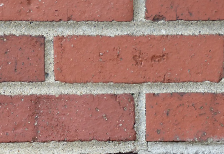 Raked-out mortar joints on an Erie brick wall ready for repointing